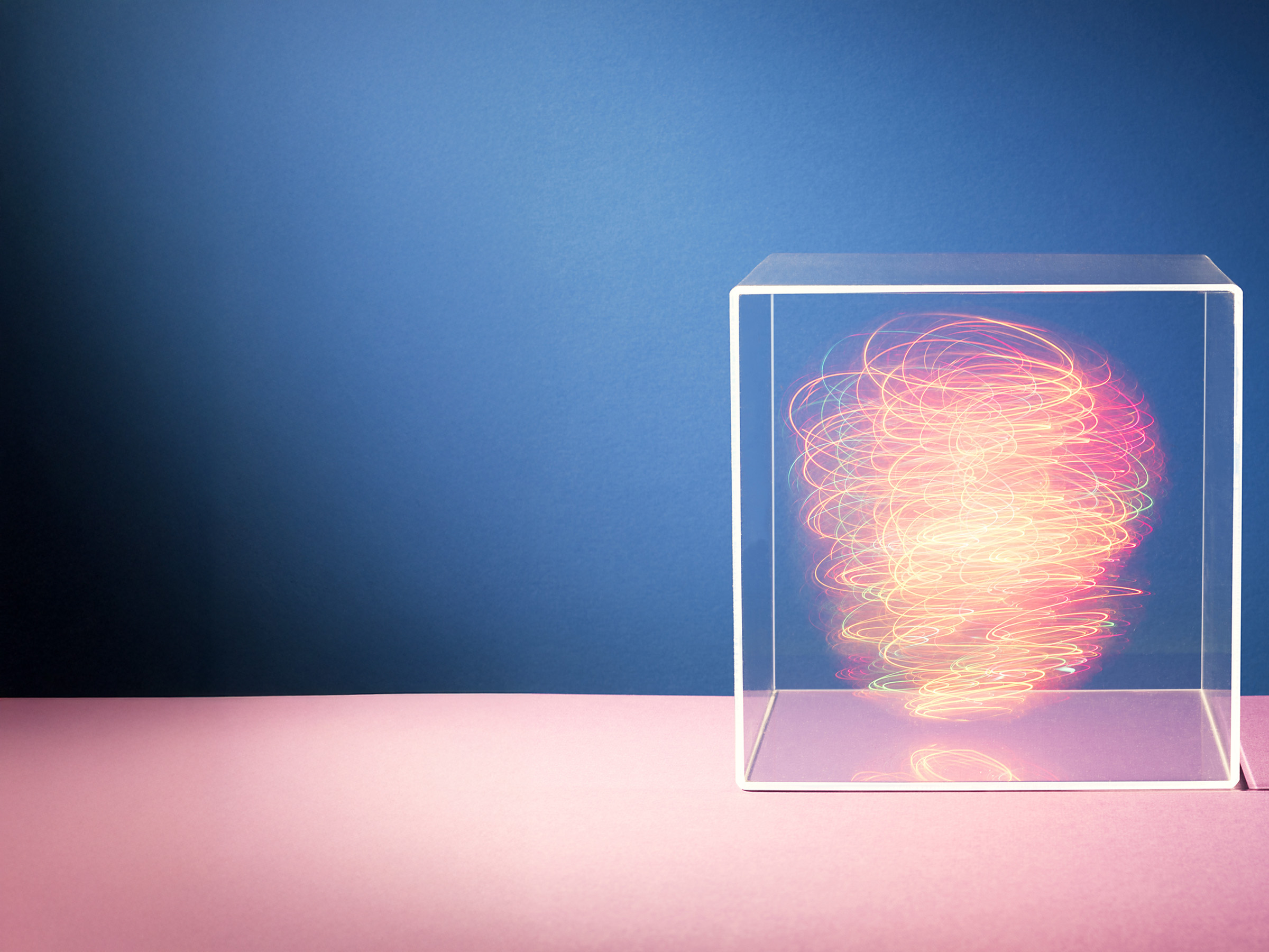 Colorful lights swirling around inside a clear box