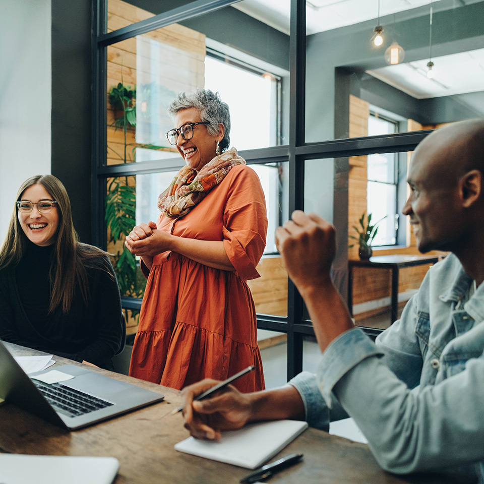Diverse businesspeople smiling cheerfully during a meeting in a modern office. Group of successful businesspeople working as a team in a multicultural workplace.